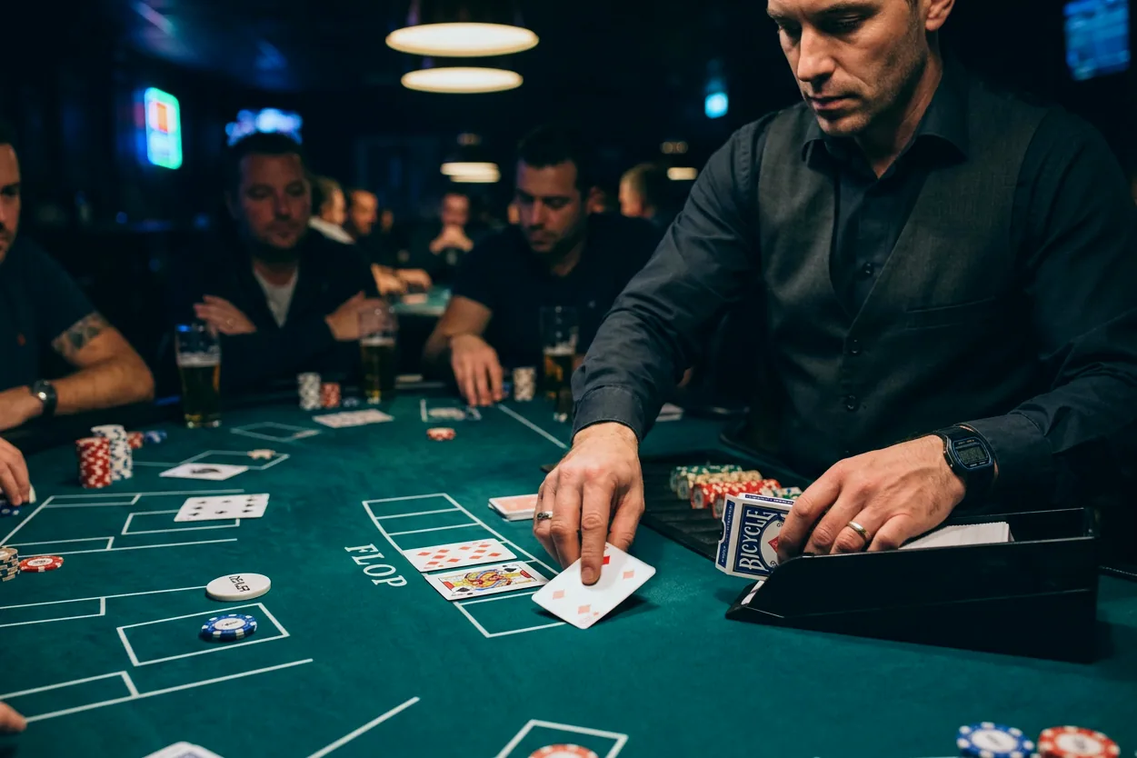 Cztery stoły pokerowe w jasnej sali na piętrze z lampami nad każdym stołem